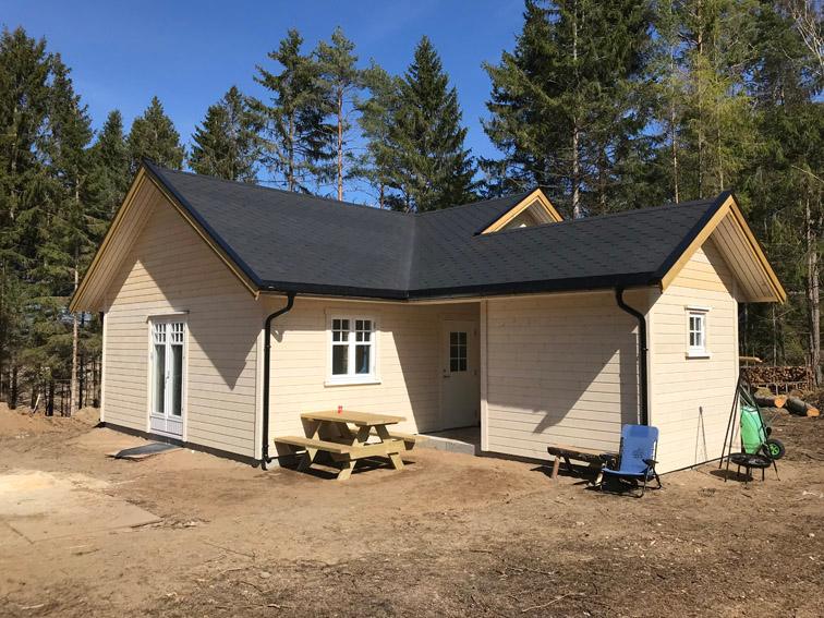 Nytt hus i lys kledning med sort tak og terrasse