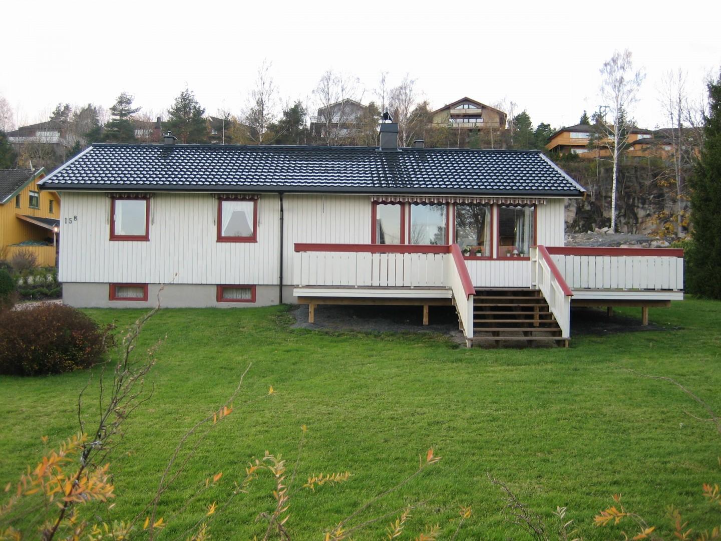 Hvitt hus med blått tak og ny terrasse